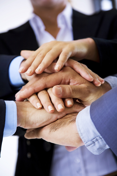 business people putting their hands on top of each other